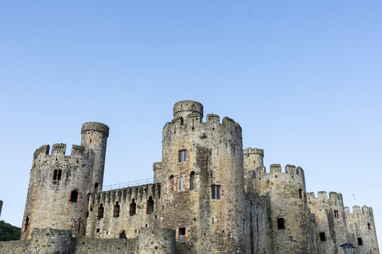 parapets, towers and turrets of Conwy Castle under blue sky.