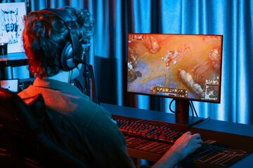 Host channel of young gaming streamer playing fighting Moba at battle arena game with multiplays team, wearing headphone on pc monitor with back side image at neon digital light modern room. Gusher.