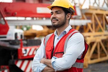 Cross arm Asia engineer man worker with  spare crane background	