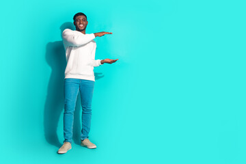 Full size photo of pretty young male hold measure empty space wear trendy white outfit isolated on aquamarine color background