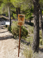 Old sign, to signal the danger of forest fires, attached with an iron to the ground next to a forest road, to prevent climate change