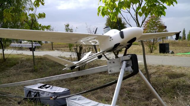A modern reconnaissance UAV with long wings on a launcher at an airfield.