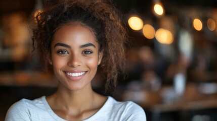 Obraz premium Smiling young woman with curly hair standing in a cafe