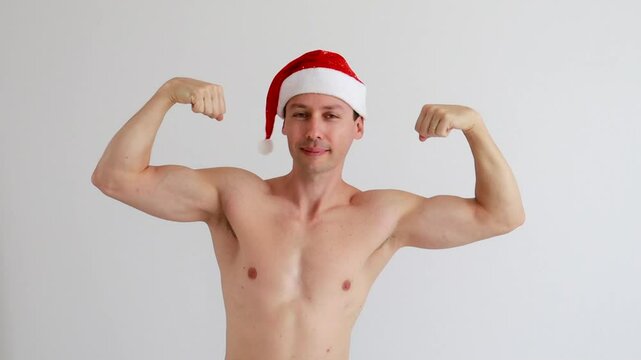 homem musculoso mostra musculos usando touca de natal 