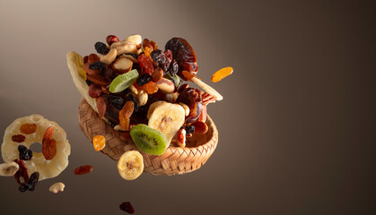 Dried tropical fruits with various nuts and raisins in motion.