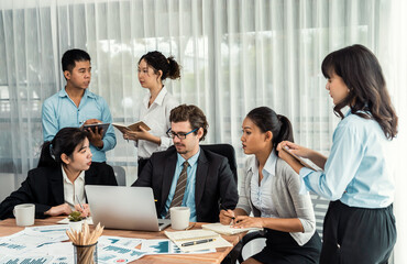Diverse of business people from various ethnic group working in modern office environment. Productive and multi ethnic office workers engage in discussion for strategic business marketing. Meticulous