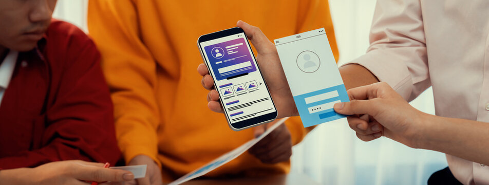 Panorama banner of startup UX developer or company employee design user interface or UI prototype for mobile application or website software with software display on smartphone in office. Synergic