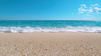 A photostock images of a sandy beach with waves gently crashing onto the shore