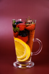 hot fruit drink with berries in a tall glass glass. Punch, mulled wine, alcoholic cocktail