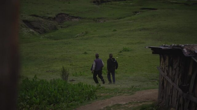 Two man waking in the greenery Meadow of Khaptad National Park, travelling in Farwest Nepal