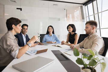 Diverse team of colleagues meeting for corporate discussion, brainstorming on work project. Business partners, stakeholders, board of directors talking at large office table, discussing teamwork