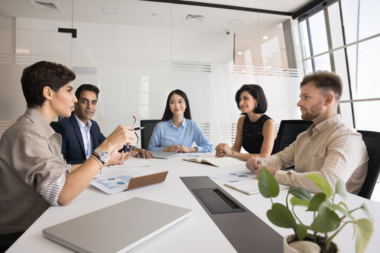 Diverse team of colleagues meeting for corporate discussion, brainstorming on work project. Business partners, stakeholders, board of directors talking at large office table, discussing teamwork