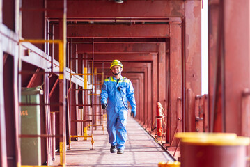 A deck officer of a merchant ship walking across the deck towards the maneuvering station during...