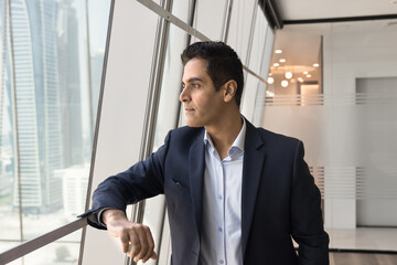 Serious middle aged Indian company leader man thinking on business ideas. Thoughtful successful...