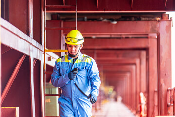 A deck officer of a merchant ship walking across the deck towards the maneuvering station during...