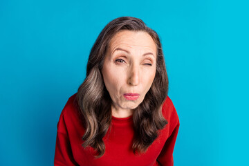 Portrait of nice aged woman look listen eavesdrop wear red sweater isolated on blue color background