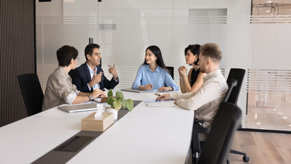 Multiethnic business team meeting at large table for teamwork, offline communication, brainstorming...