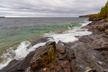 Dark Limestone Platforms in Turquoise waters of Lake Huron, shoreline coast beach near Cyprus Lake, stormy autumn day