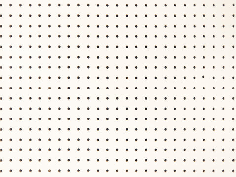 Background of white peg board with holes