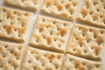 closeup of saltine crackers on white background