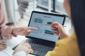 Data Driven Collaboration: A close-up view of a team collaborating over a laptop, analyzing data on a digital chart.