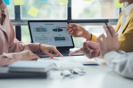 Data Driven Decisions:  A team of professionals analyze data on a laptop, collaborating on strategy and insights.  They point at charts and graphs, demonstrating their expertise and focus on results.