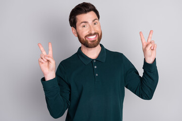 Photo of cheerful good mood attractive man wear stylish green clothes v-sign isolated on gray color background