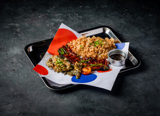 Filipino Grilled Pork Belly with Garlic Rice, Grilled Vegetables, and Sauce served in tray isolated on grey background side view of platter meal
