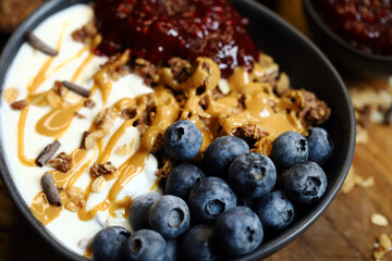 bowl with chocolate granola white yogurt peanut butter and raspberry jam