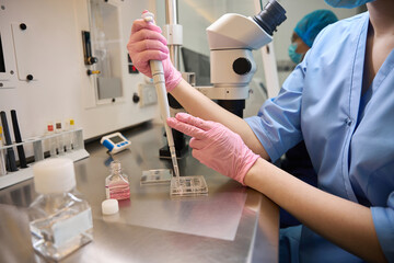 Caucasian embryologist conducting cell culture preparation in a laboratory