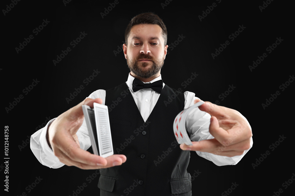 Poster Professional croupier shuffling cards on black background