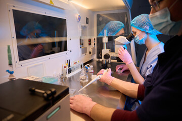 Doctors conducting a synchronized procedure in a sterile lab