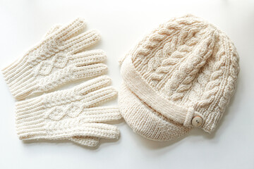 真っ白い毛糸で編まれたアラン模様の帽子と手袋　白背景　モックアップ