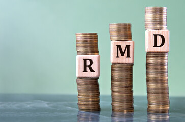 RMD - acronym on wooden cubes on stacks of coins
