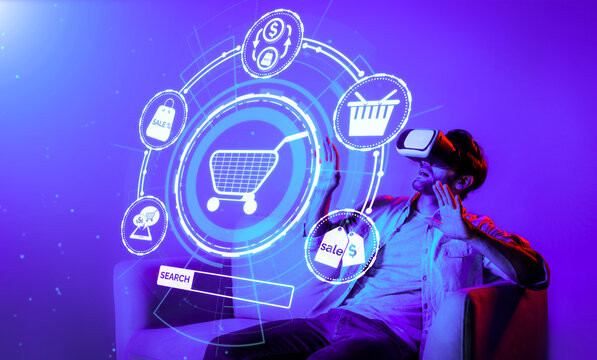 Happy man using VR headset and shopping online while sitting at sofa with shopping bags. Smart person looking at online market hologram and icon with neon background. Innovation technology. Deviation.