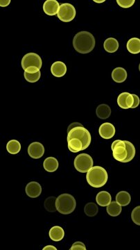vertical animation of luminous yellow round shapes floating against a black background for festive designs