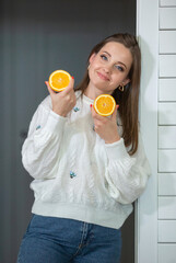 Healthy food concept. A young beautiful girl holds orange halves in her hands