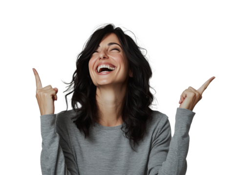 Joyful woman celebrating indoors with a bright smile and raised hands while wearing a cozy sweater