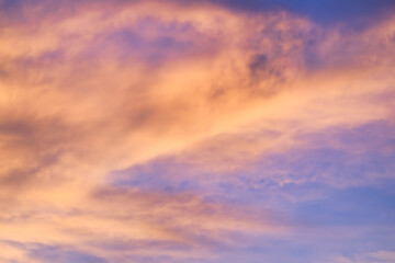 A beautiful sky tinted by the sun leaving vibrant shades of gold, pink, blue and multicolored. Clouds in the twilight evening and morning sky. Cloudy sky background in the evening, and during the day.