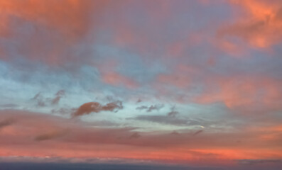 Obraz premium A beautiful sky tinted by the sun leaving vibrant shades of gold, pink, blue and multicolored. Clouds in the twilight evening and morning sky. Cloudy sky background in the evening, and during the day.
