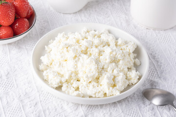 Cottage cheese and strawberries on a white table