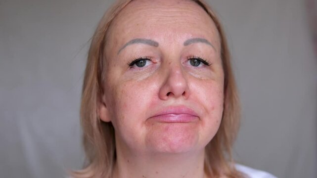 Portrait the fingers holding the flabbiness adipose sagging skin, Flabby skin and loose, swelling and ptosis beside the eyelid, dark spots and wrinkle on the face, health care and beauty concept.