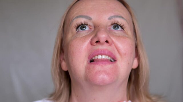 Portrait the fingers holding the flabbiness adipose sagging skin, Flabby skin and loose, swelling and ptosis beside the eyelid, dark spots and wrinkle on the face, health care and beauty concept.