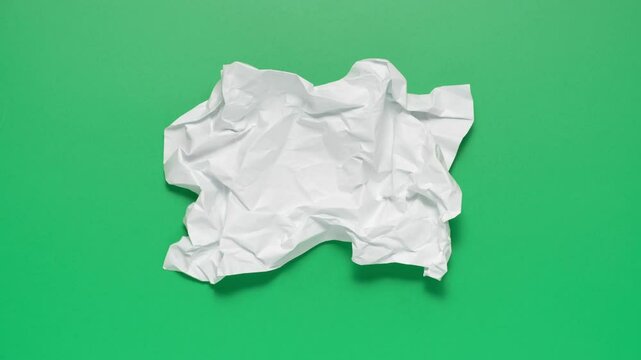 Stop motion animation of crumpled paper on a green background