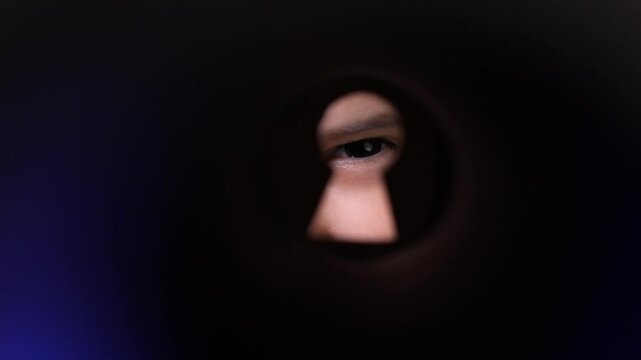 child looking through keyhole peeping through door