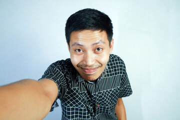 gesture of an Asian man taking a selfie at the camera. White background 