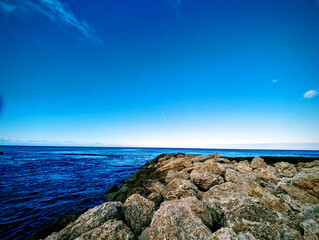 Tranquil morning at Ko Olina Lagoon with clear blue skies and rocky shore