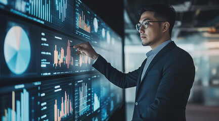 A professional man in business attire stands before an interactive digital wall displaying various graphs and charts with data visualization graphics.
