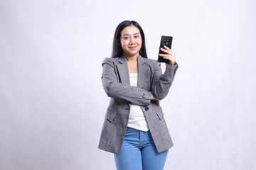 beautiful young office girl asia smile to camera and hold cellphone wearing grey suit isolated on white background. for technology, lifestyle, shopping, transaction content