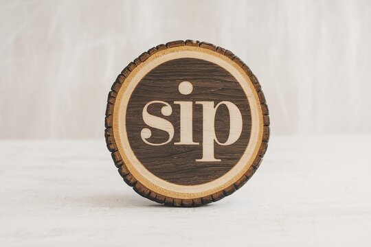 Wooden coaster with engraved 'sip' text on tree trunk slice